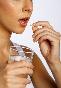 Woman Holding Glass of Water and Green Coffee Supplement