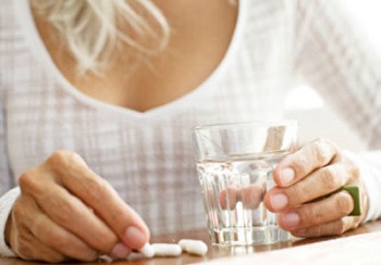 Woman with Glass of Water and Joint Supplements