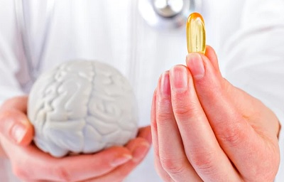 Doctor Holding Fish Oil Supplement and Brain Figure