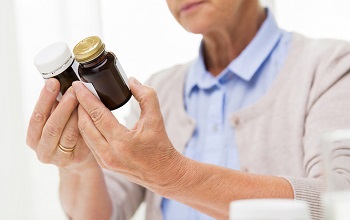 Elderly Woman Reading Supplement Label